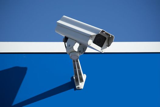 Security surveillance camera on the side of an industrial building