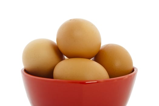 brown eggs in red bowl on white background