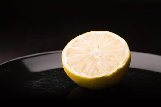 Cut lemon halve on a black dish