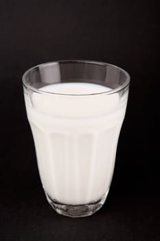 Milk in glass on a black background