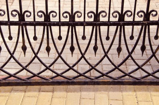 Old metal gate fragment. Beautiful forged metal ornaments.