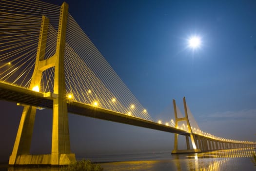 Long Vasco da Gama bridge at night under moonlight