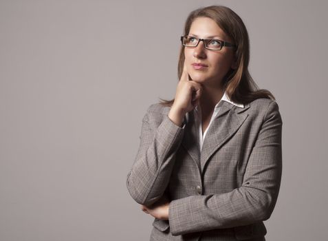 portrait of a young successful woman, looks up and thinks