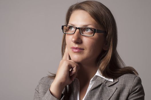 portrait of a young successful woman, looks up and thinks