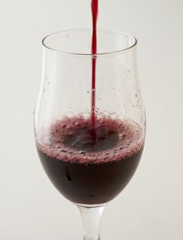 Red wine pouring in a big glass