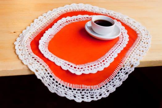 A coffee cup on two orange napkins
