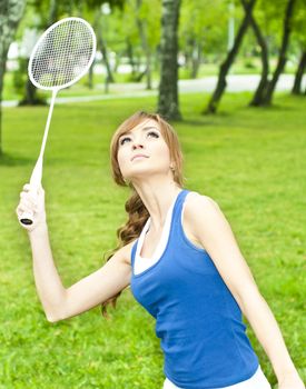 Beautiful Young Woman with Badminton racket, in the summer park