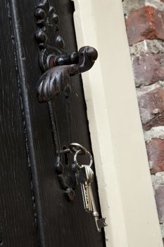 Close up of black doorknob with keys in keyhole
