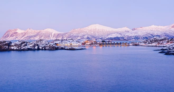 Panorama. Polar night in Norway. Mountains, fjords, and the moon, typical Norwegian house