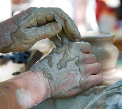 Potter shaping a ceramic pot on a pottery wheel