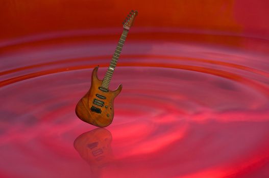 guitar and shadow on red water