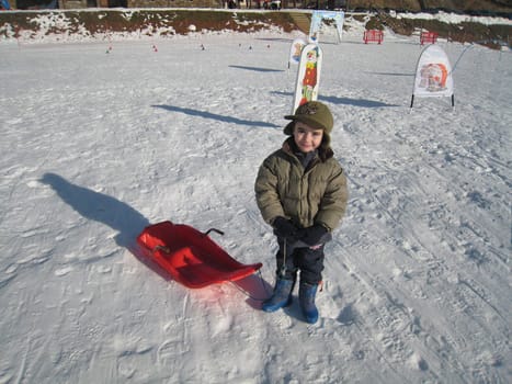 kid with sledge in Pyrenean mountains, south France