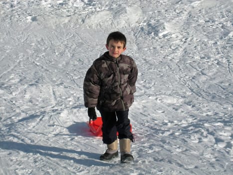 kid with sledge in Pyrenean mountains, south France