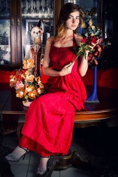 View of a beautiful young girl in a red dress on a living room.