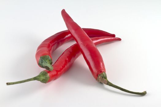 A pile of red hot chili peppers isolated on white background