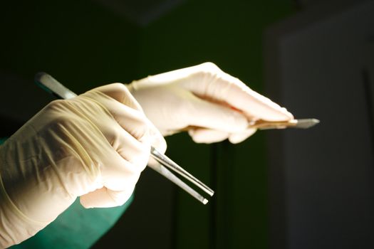 Hand with tweezers and sclapel surgeon photo