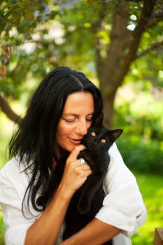 dark haired woman with a cat outdoor