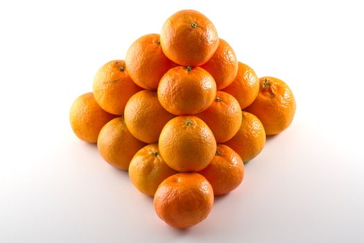 Clementines arranged in a pyramid shape isolated on white background