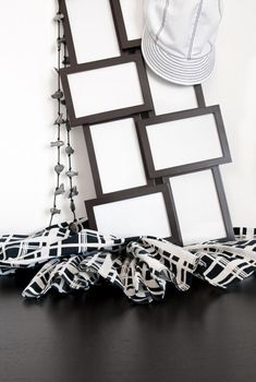 Black and white clothing and photo frames with copy space on wooden surface.