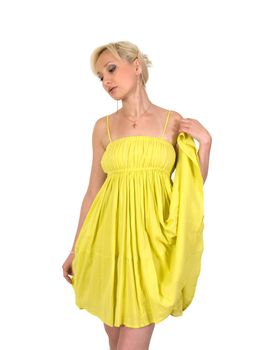 Blonde in yellow summer dress looks down thoughtfully.