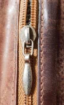 an image of zipper on brwon leather