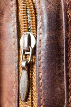 an image of zipper on brwon leather
