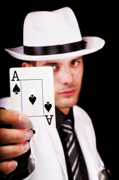 View of a white suit man with hat holding an ace card.