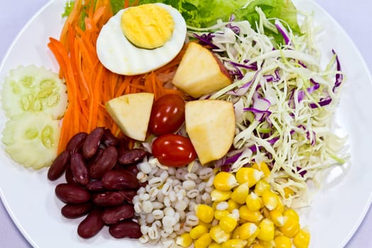 Fruit salad with boiled egg on a white plate