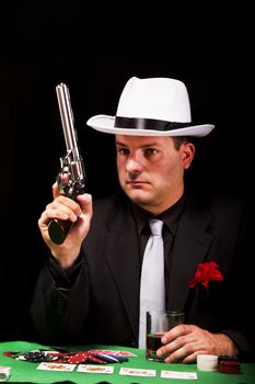 View of a dark suit gangster man holding a gun.