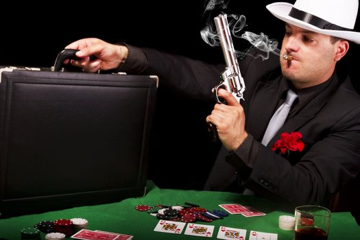 View of a white suit gangster man holding a gun and a briefcase.