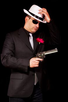 View of a dark suit gangster man holding a gun.