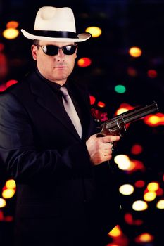 View of a dark suit gangster man holding a gun.