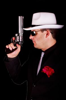 View of a dark suit gangster man holding a gun.