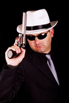 View of a dark suit gangster man holding a gun.