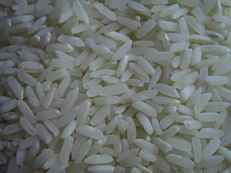 A photograph of uncooked white rice detailing its texture.