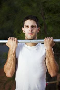 Close view of a young man doing exercise on a park.