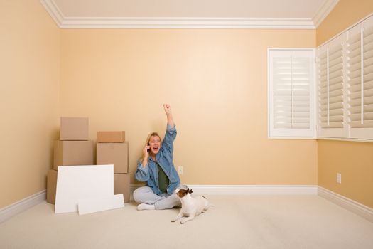 Pretty Woman on the Floor Using Phone Celebrating with Moving Boxes, Blank Signs and Dog in Empty Room.