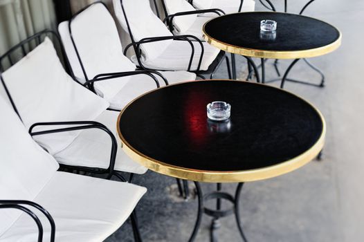 Black round tables and chairs in the street cafe. Paris