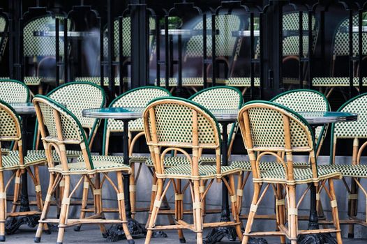 Wicker chairs in the typical cafe in Paris. Photo with tilt-shift effect