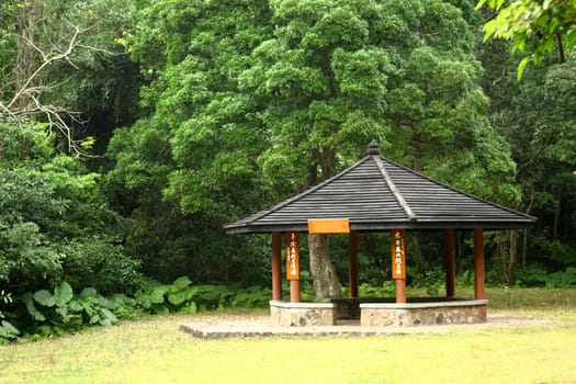 Small pavilion among nature with forest background at day