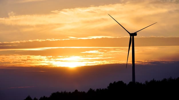 Wind turbine farm over sunset