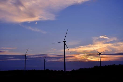 Wind turbine farm over sunset