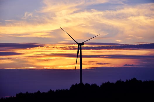 Wind turbine farm over sunset