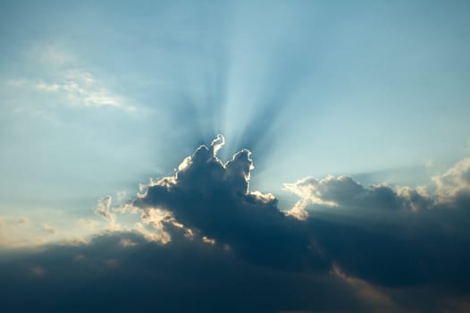 sun rays behind dark blue cloud, high contrast, photo can be used as an religious concept background