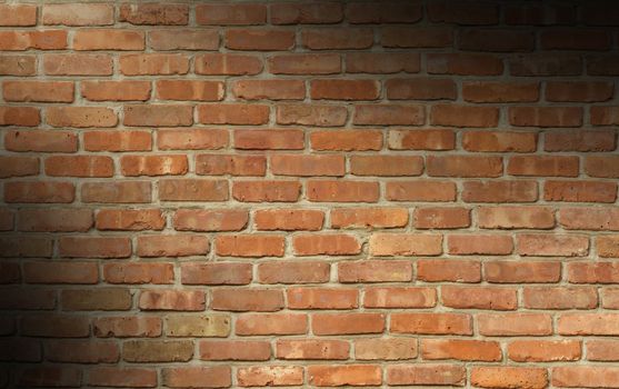 Weathered red brick wall texture lit diagonally