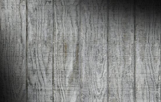 Weathered gray wooden barn siding using vertical planks lit diagonally