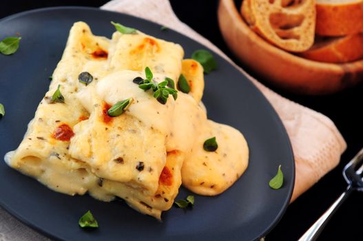 Cheese cannelloni pasta served on a plate with alfredo sauce