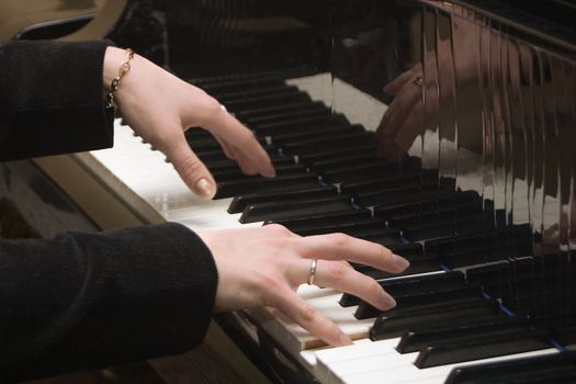 Hands of the pianist playing on a piano