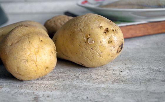Whole healthy potatoes in a kitchen background