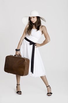 Fashion woman posing with a old suitcase and a white dress